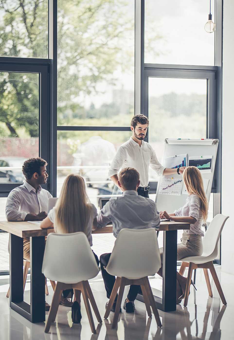 Group of young multiracial people working in modern light office. Businessmen at work during meeting.